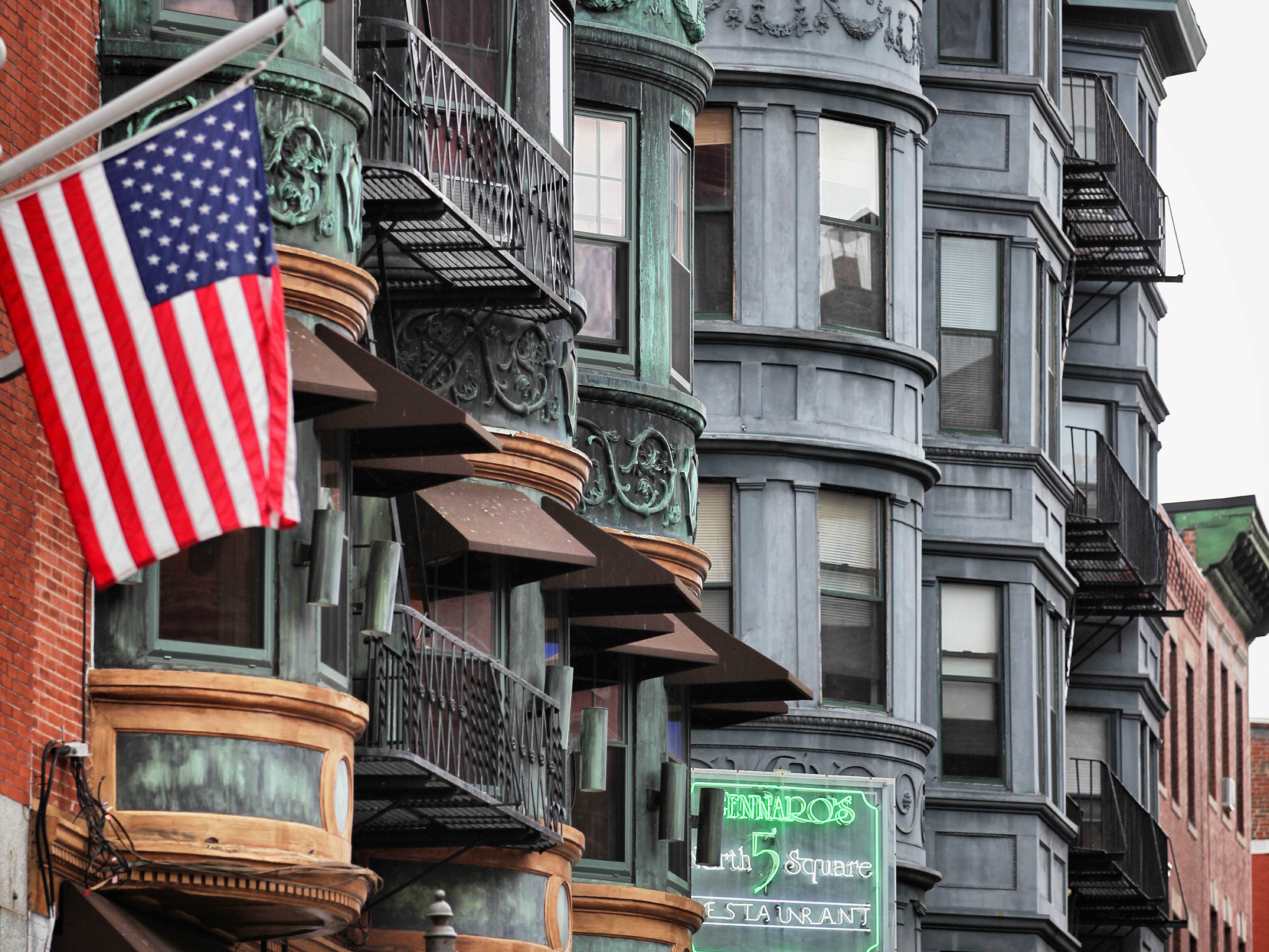 Amerikaanse vlag wappert aan de huizenrijen met balkonnen