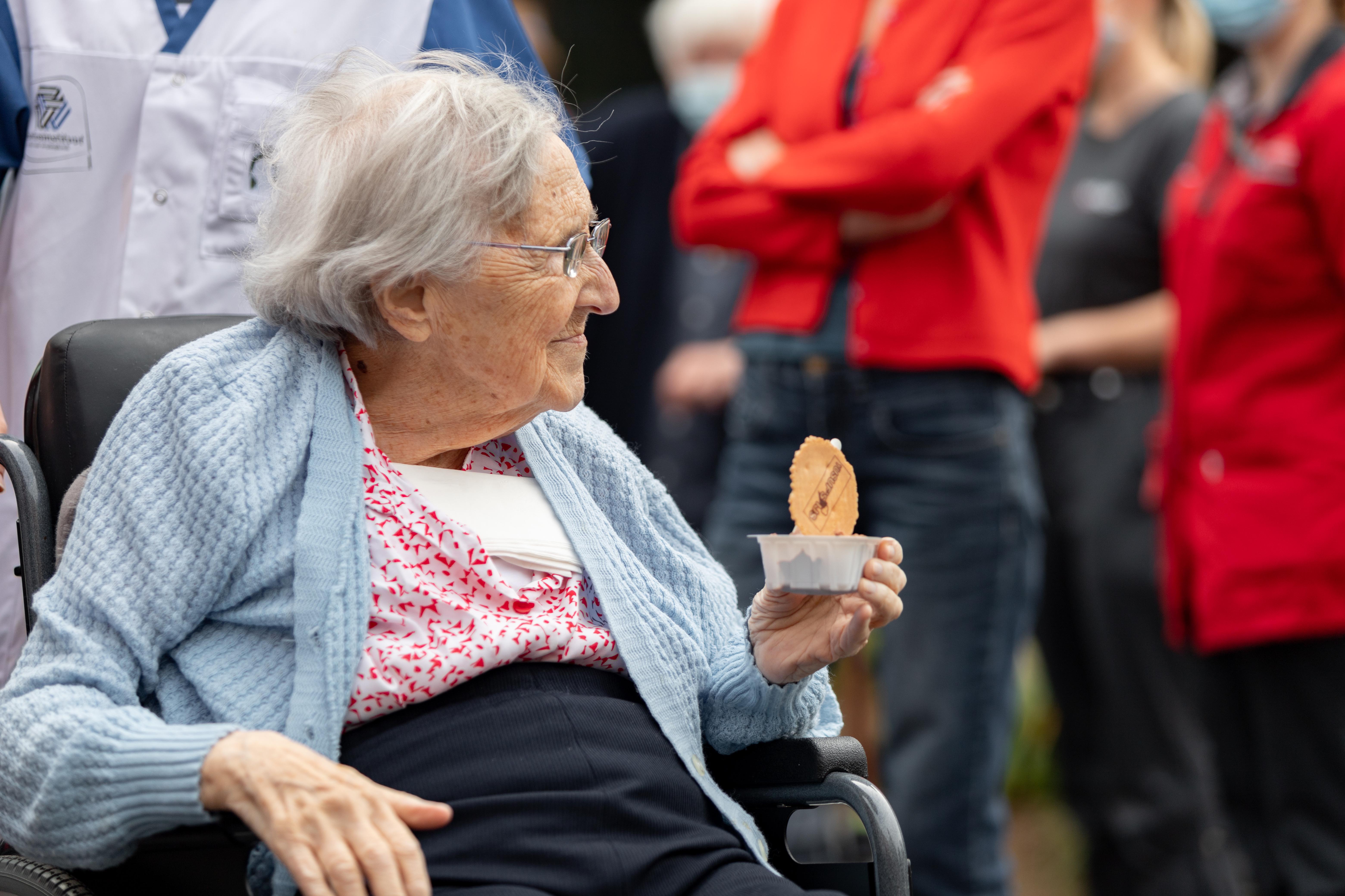 Oudere dame in rolstoel genite van een ijsje in woonzorgcentrum de Refuge in Gent