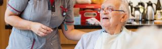 Zorgkundige in woonzorgcentrum de Refuge Gent ondersteunt senior bij het eten 