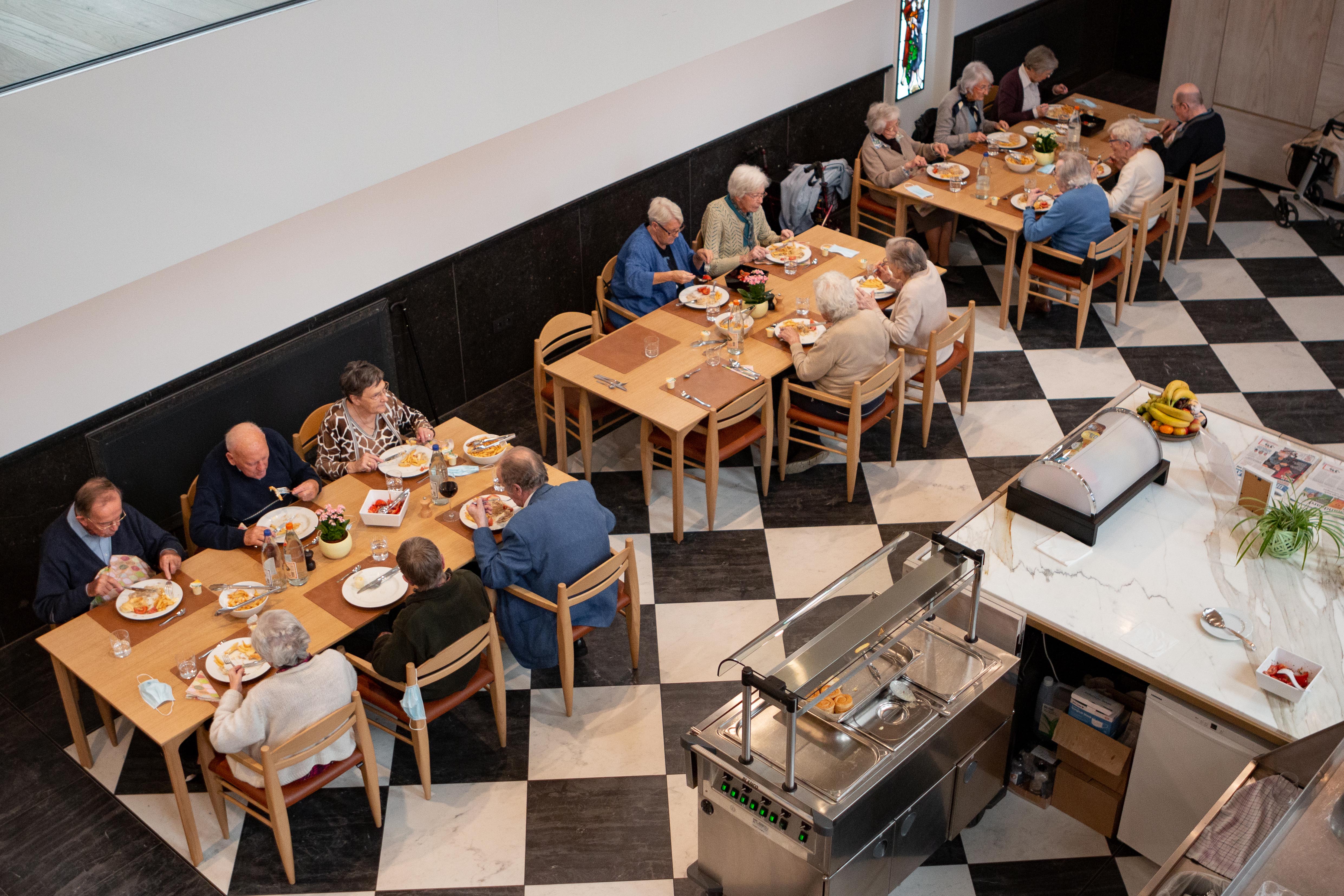 de bewoners van Dorp in de Stad aan het lunchen