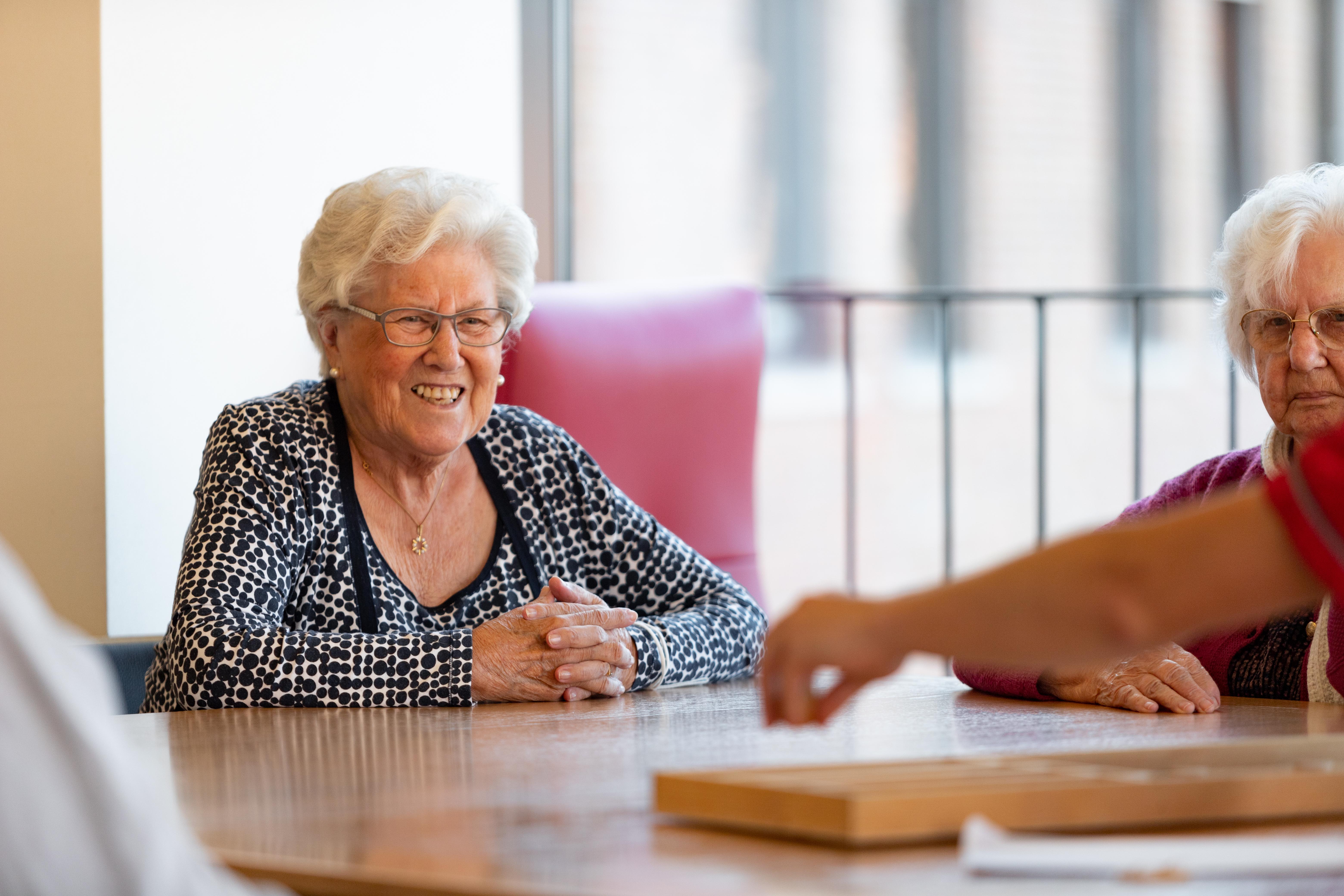 Bewoners aan het sjoelbakken in de Refuge Gent