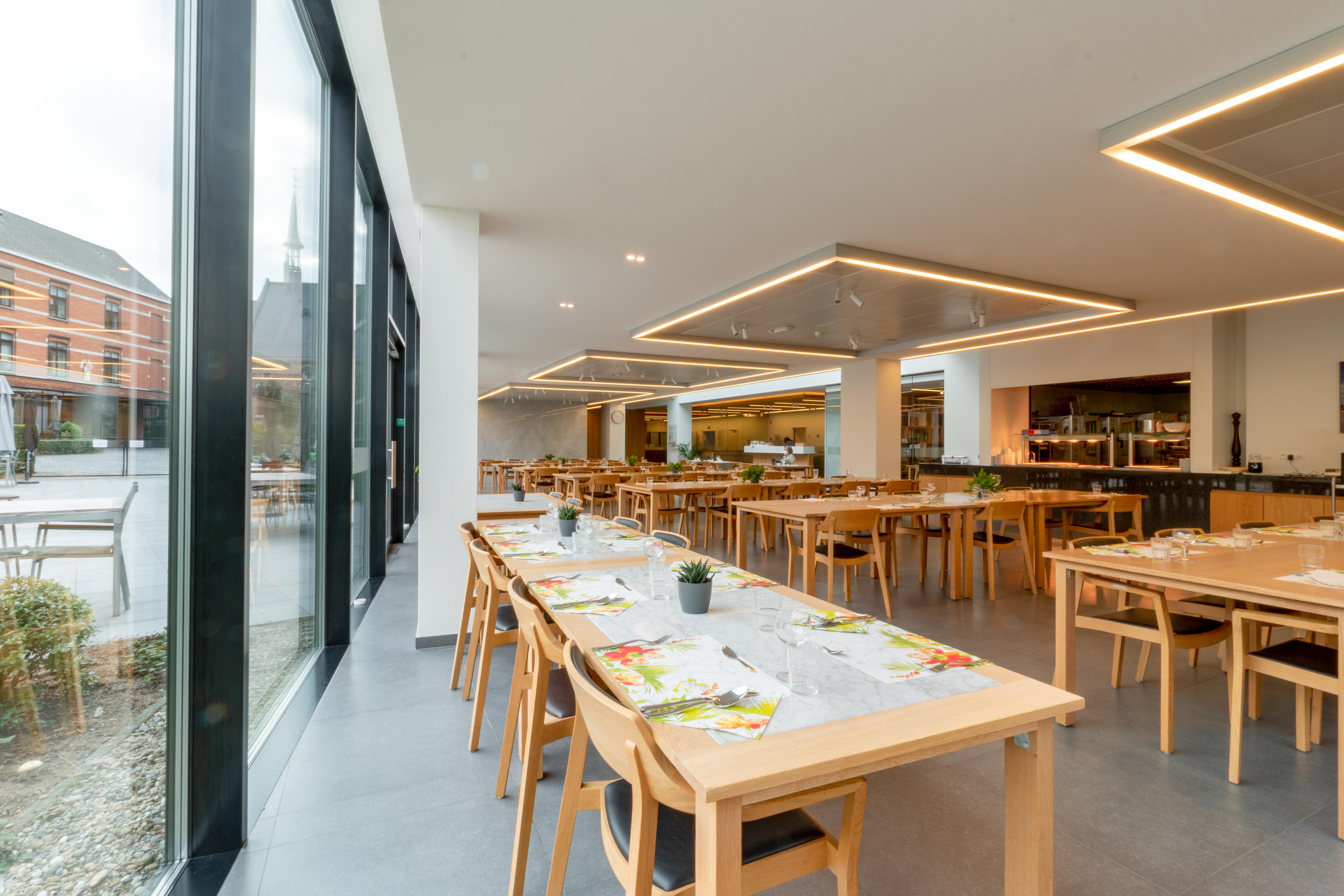 Het restaurant van woonzorgcentrum de Refuge in Gent is helder dankzij de vele raampartijen. 