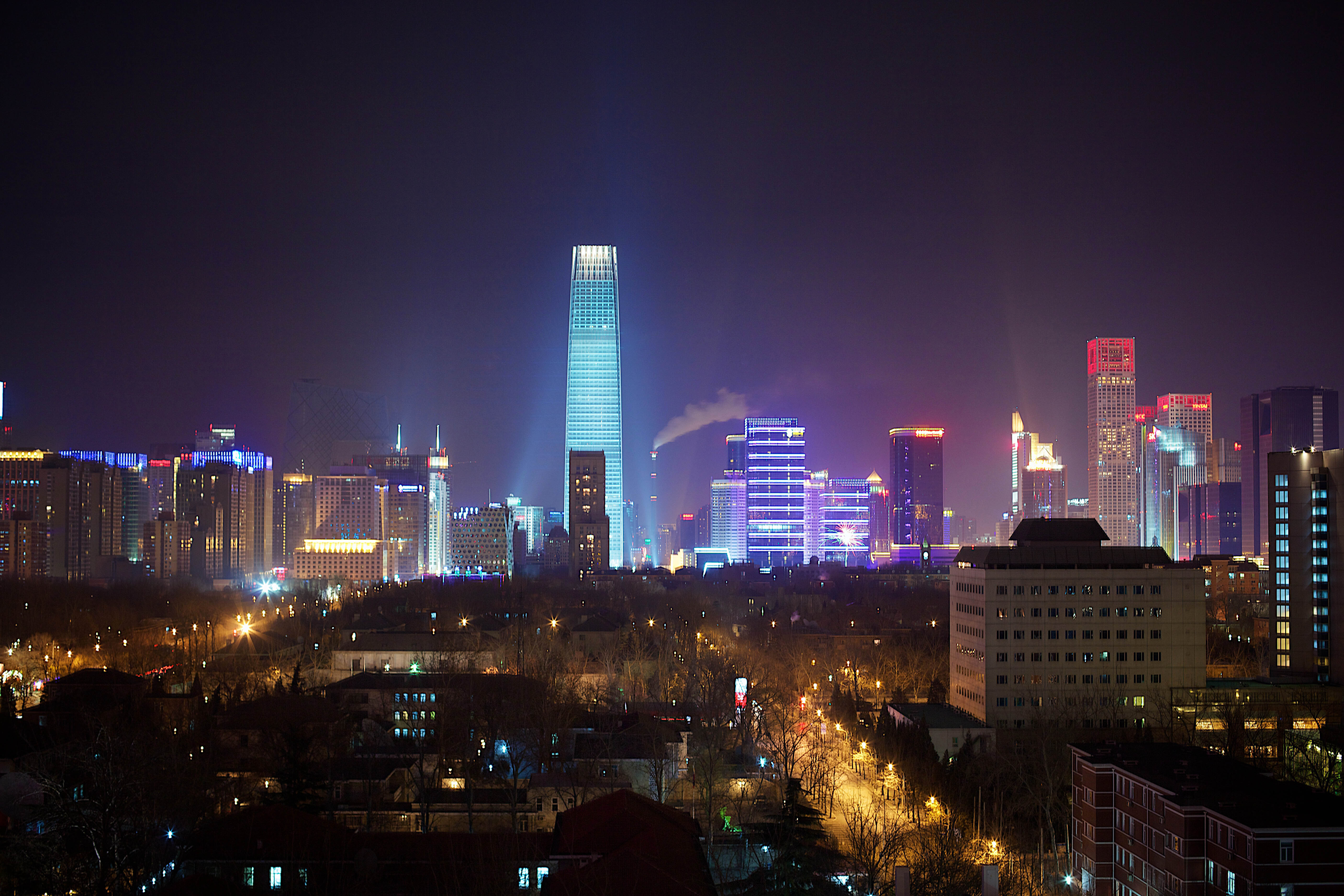 Skyline in de nacht met blauw verlichte toren